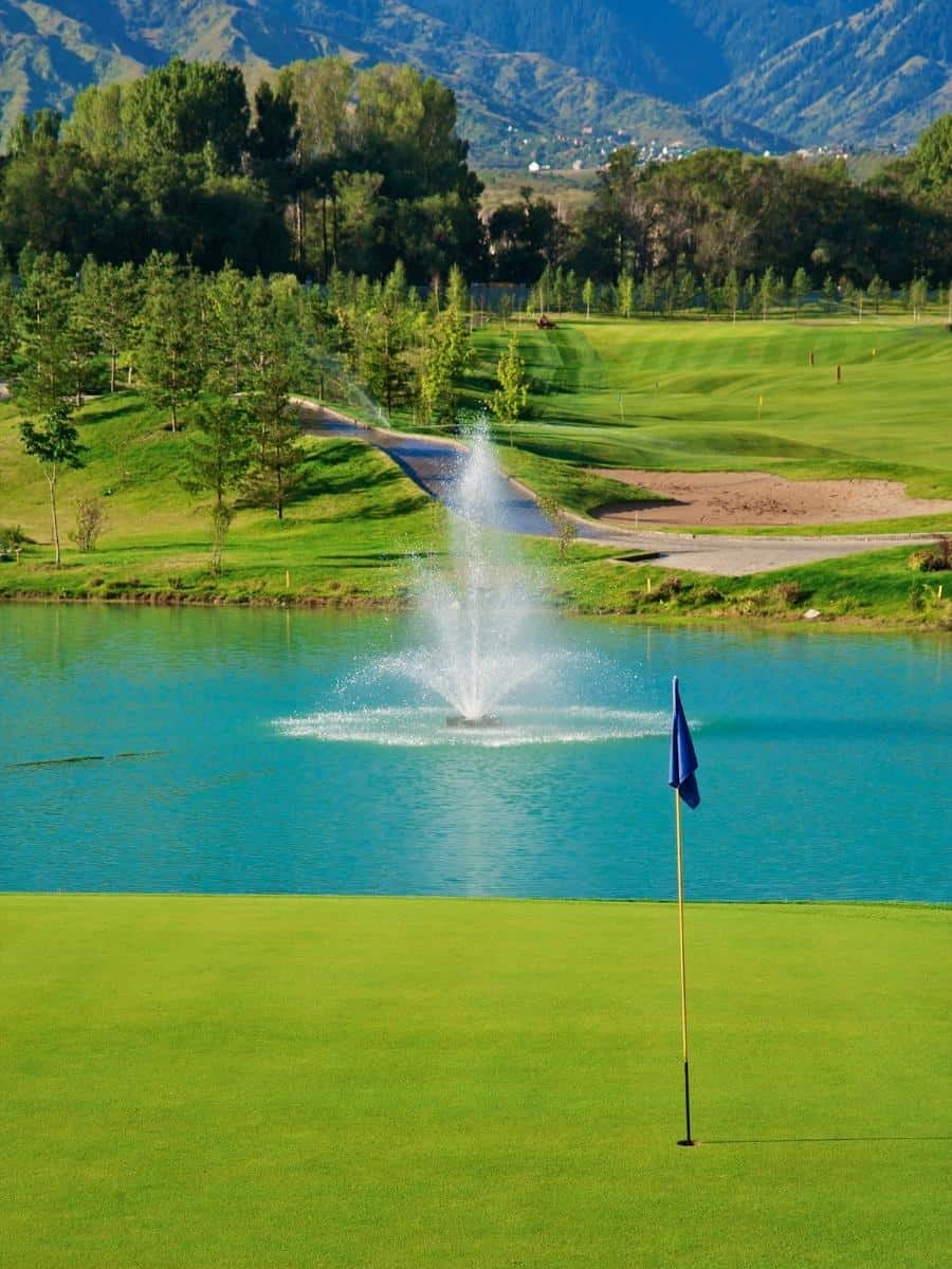Golf Green Next to Lake With a Fountain