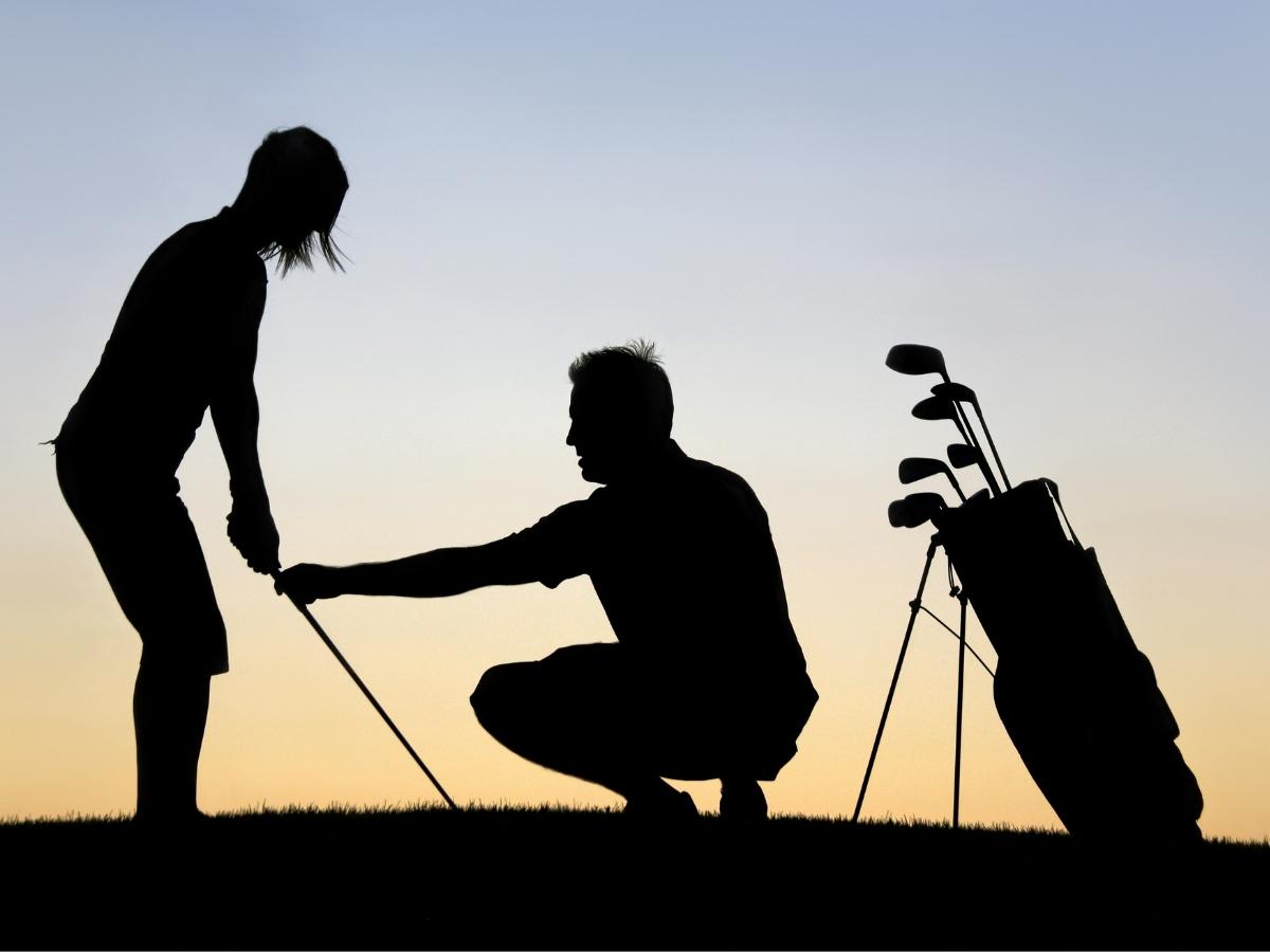 A Golfer having a Golf Lesson.